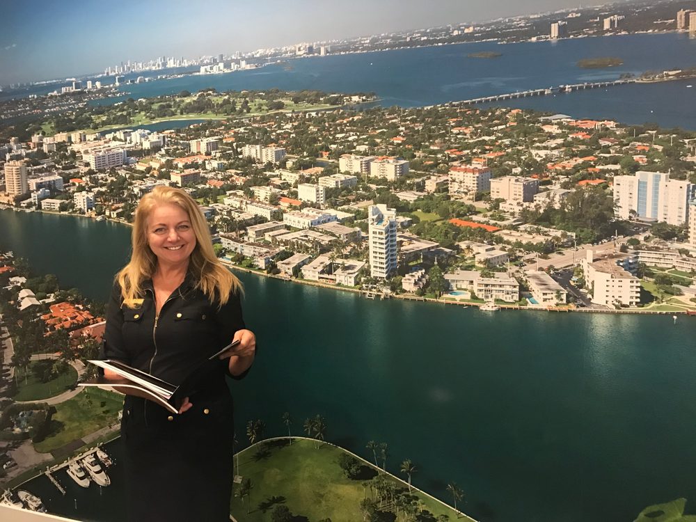 Erika Meyer, REALTOR®, smiling in front of a South Florida waterfront view